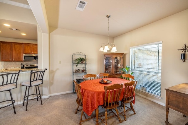 dining room featuring a notable chandelier, baseboards, visible vents, and light colored carpet