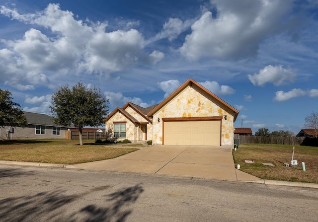 view of front of property with concrete driveway, a front yard, fence, a garage, and stone siding