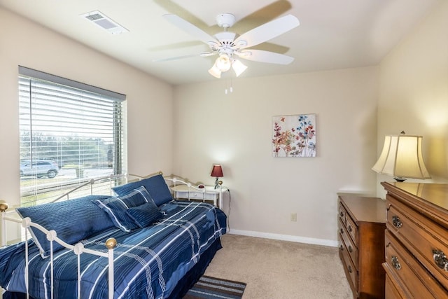 bedroom with a ceiling fan, visible vents, light carpet, and baseboards