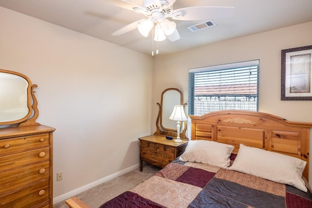 bedroom with light carpet, ceiling fan, visible vents, and baseboards