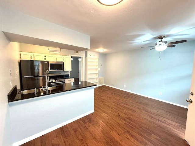 kitchen with appliances with stainless steel finishes, sink, white cabinetry, ceiling fan, and dark wood-type flooring