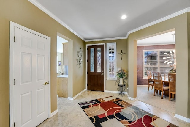 tiled entryway featuring ornamental molding and a chandelier