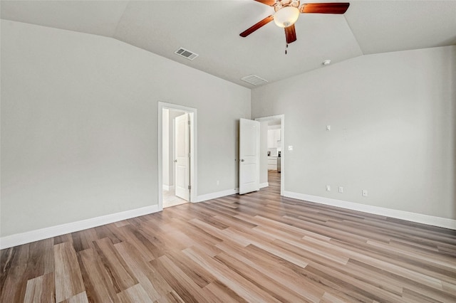 interior space with ceiling fan, vaulted ceiling, connected bathroom, and light hardwood / wood-style floors