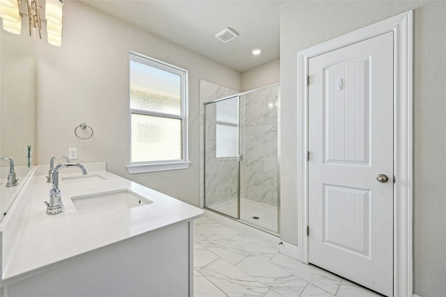 bathroom featuring a shower with door and vanity