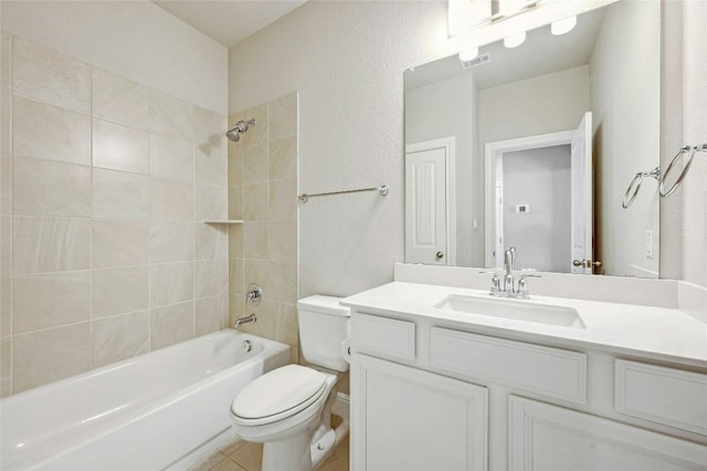 full bathroom with tiled shower / bath combo, tile patterned floors, vanity, and toilet