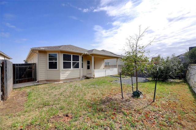 rear view of property featuring a yard