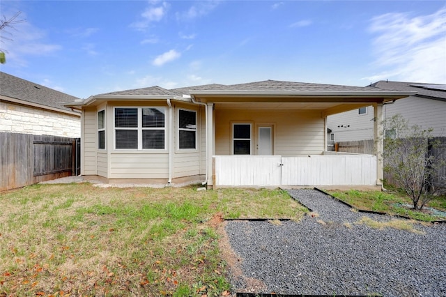 rear view of house featuring a yard