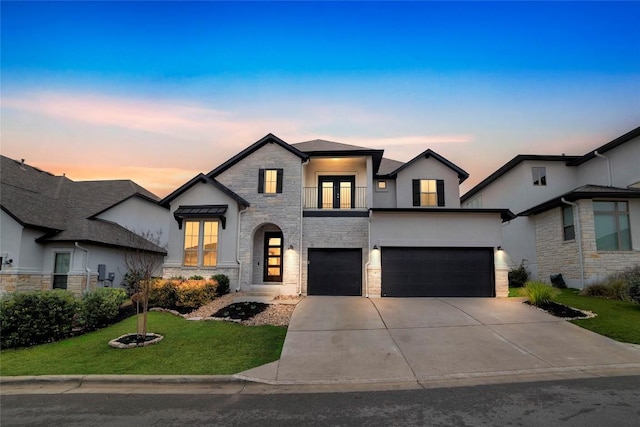 view of front of house featuring a garage, a balcony, and a yard