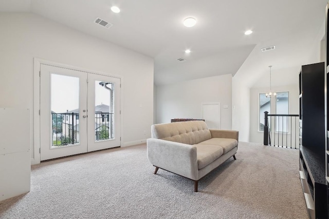 sitting room with a chandelier, vaulted ceiling, light carpet, and french doors