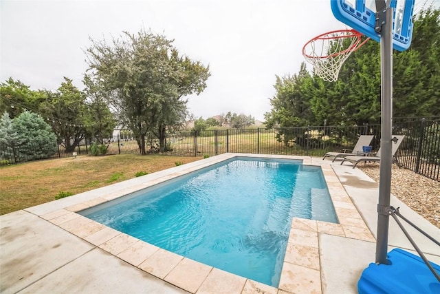 view of pool with a patio and a lawn