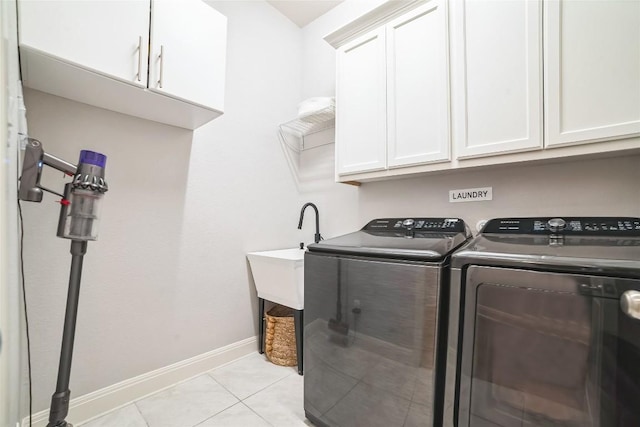 laundry room featuring light tile patterned flooring, cabinets, and separate washer and dryer