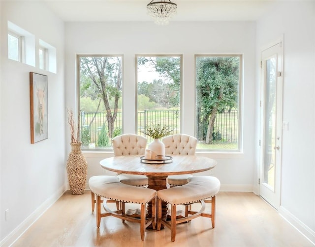 sunroom / solarium featuring a chandelier