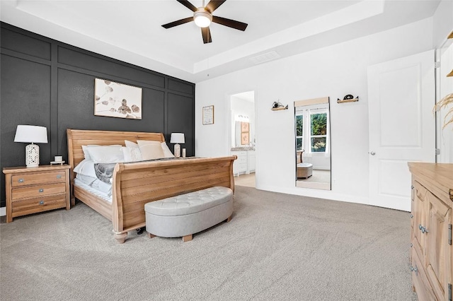 bedroom featuring ceiling fan, a raised ceiling, and carpet