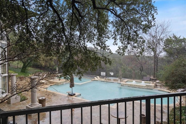 view of swimming pool featuring a hot tub and pool water feature