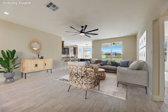 living room featuring light wood-type flooring and ceiling fan