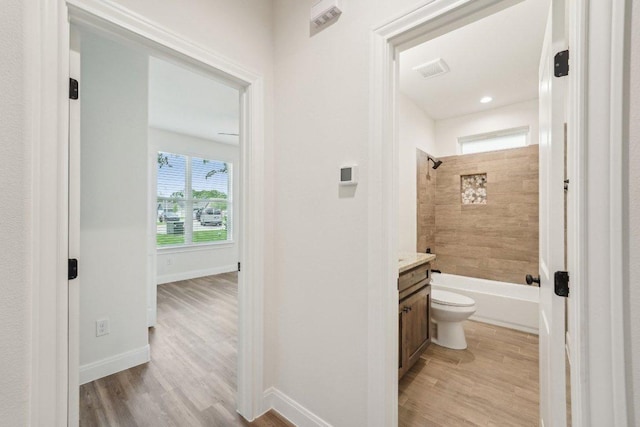 bathroom featuring baseboards, wood finished floors, vanity, and toilet