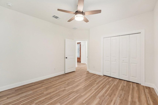 unfurnished bedroom with light wood-style flooring, baseboards, visible vents, a closet, and ceiling fan