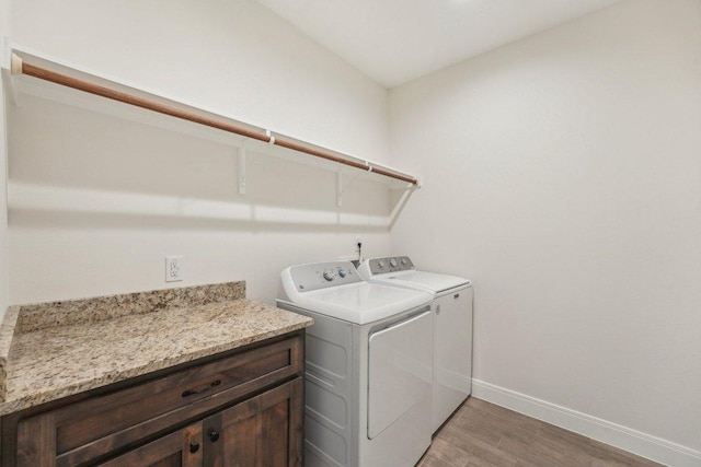 laundry area with light wood-style floors, washing machine and clothes dryer, baseboards, and laundry area