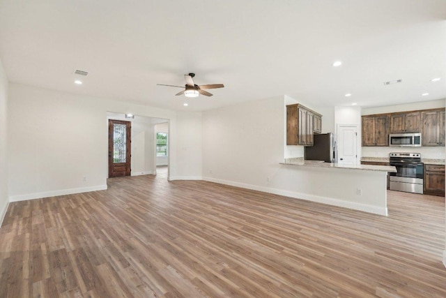 unfurnished living room with light wood-type flooring, a ceiling fan, visible vents, and recessed lighting