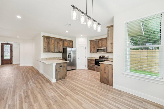 kitchen featuring light wood-style floors, baseboards, a peninsula, appliances with stainless steel finishes, and visible vents