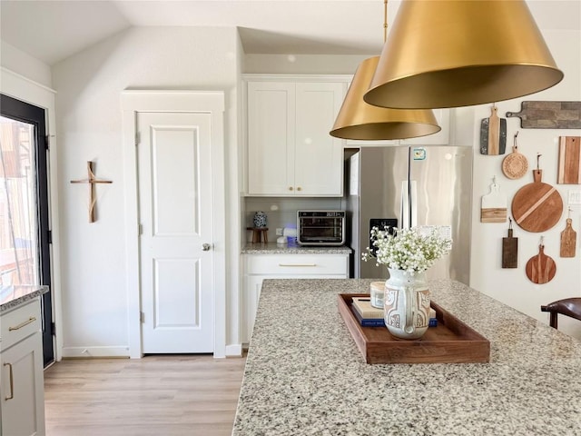 249 Earl Keen St, Leander, TX 78641 - kitchen with stainless steel fridge with ice dispenser, light wood-style floors, light stone countertops, white cabinets, and lofted ceiling