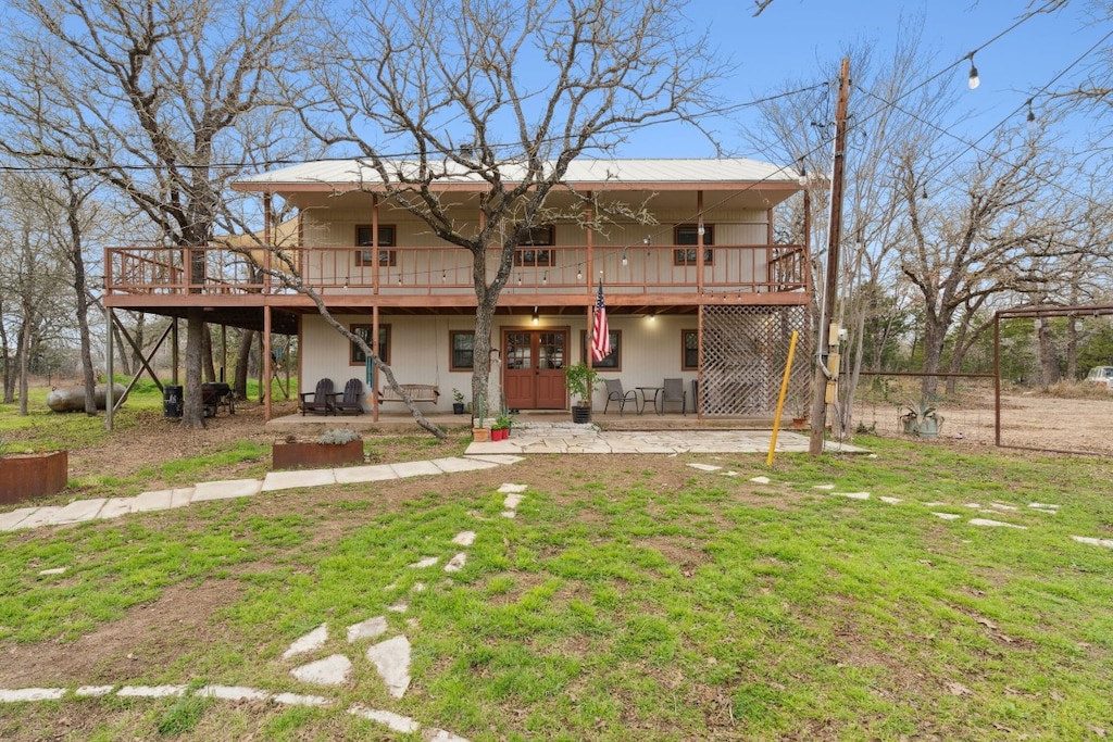 view of front facade featuring a deck, a front lawn, and a patio area
