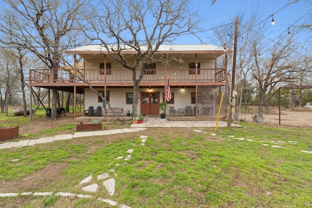 view of front facade featuring a deck, a front lawn, and a patio area