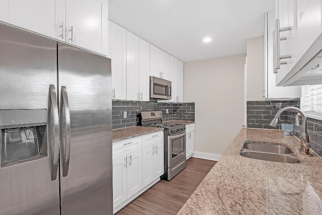 1808 Belford Dr, Austin, TX 78757 - kitchen with stainless steel appliances, light stone counters, tasteful backsplash, white cabinets, and recessed lighting