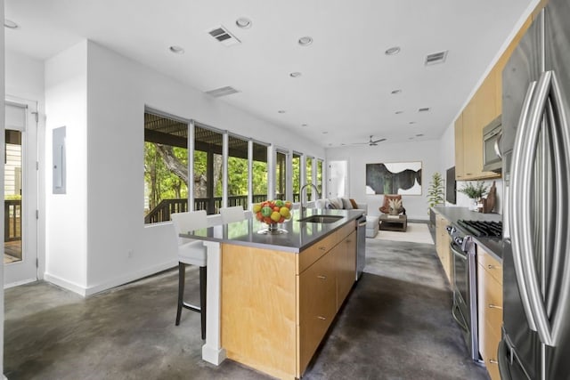 kitchen featuring a center island with sink, visible vents, open floor plan, stainless steel appliances, and a sink