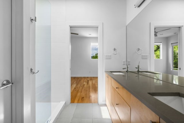 bathroom with vanity, tiled shower, tile patterned floors, and a healthy amount of sunlight