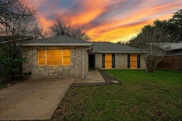 back house at dusk with a lawn