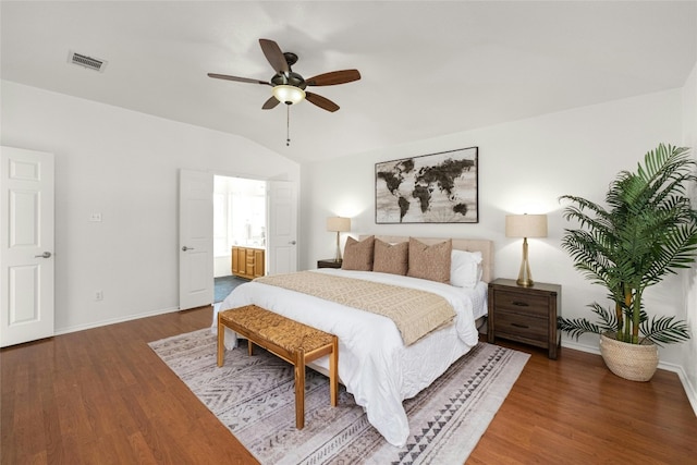 bedroom with ceiling fan, dark wood-type flooring, ensuite bath, and lofted ceiling