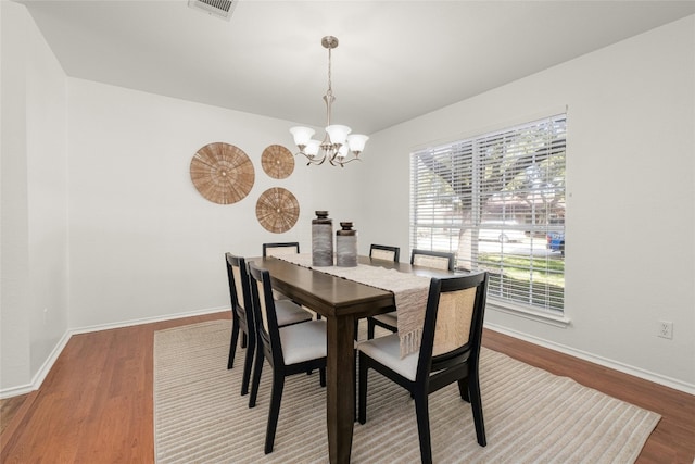 dining space with a chandelier and wood-type flooring