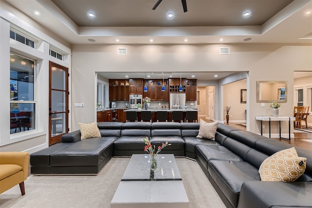 living room featuring a tray ceiling and a high ceiling