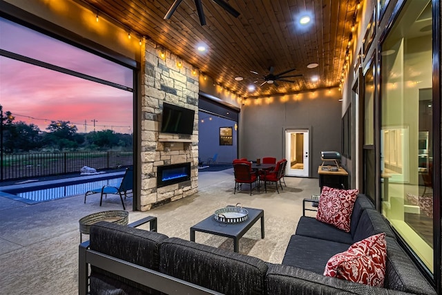 view of patio with ceiling fan and an outdoor living space with a fireplace