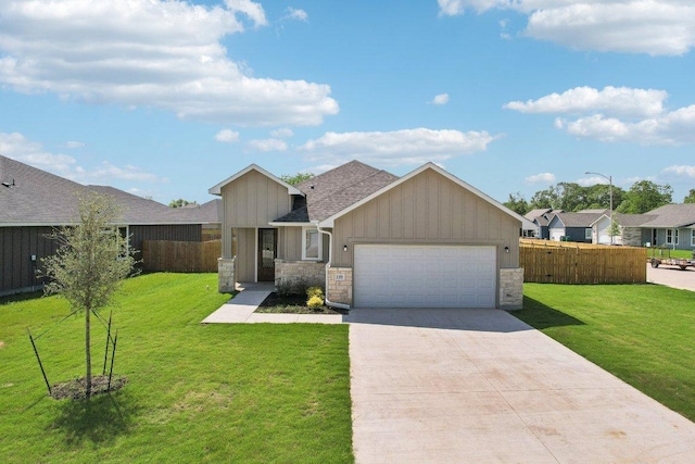 view of front of house with an attached garage, fence, driveway, and a front yard