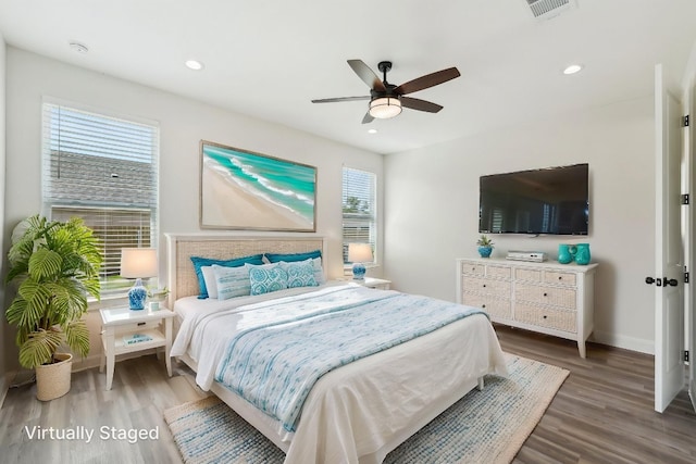 bedroom with wood finished floors, visible vents, a ceiling fan, and baseboards