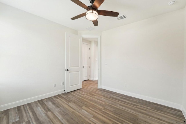 unfurnished room with baseboards, a ceiling fan, wood finished floors, and visible vents