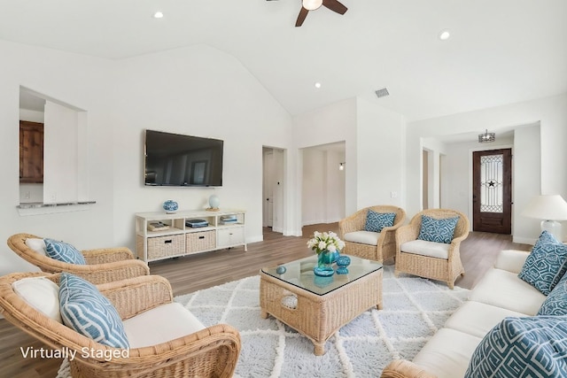 living area with light wood finished floors, visible vents, recessed lighting, ceiling fan, and high vaulted ceiling