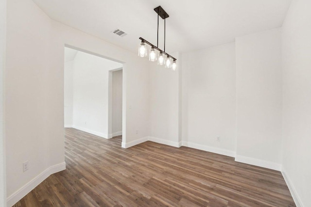 unfurnished dining area with baseboards, visible vents, and dark wood-style floors