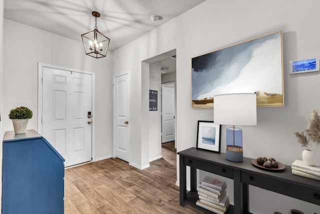 entryway with hardwood / wood-style flooring and a chandelier