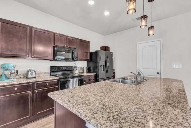 5812 Brampton Ln, Austin, TX 78724 - kitchen with black appliances, a sink, pendant lighting, dark brown cabinets, and light wood finished floors