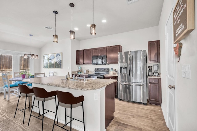 kitchen with a center island with sink, hanging light fixtures, stainless steel refrigerator with ice dispenser, electric stove, and sink