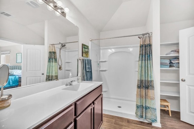 5812 Brampton Ln, Austin, TX 78724 - ensuite bathroom featuring a shower with shower curtain, wood finished floors, vanity, and lofted ceiling