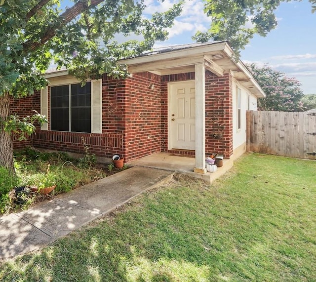 view of exterior entry with a lawn