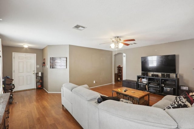 17405 Wiseman Dr, Pflugerville, TX 78660 - living area featuring arched walkways, wood finished floors, baseboards, and ceiling fan