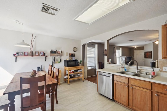 17405 Wiseman Dr, Pflugerville, TX 78660 - kitchen featuring dishwasher, a sink, black microwave, arched walkways, and light countertops