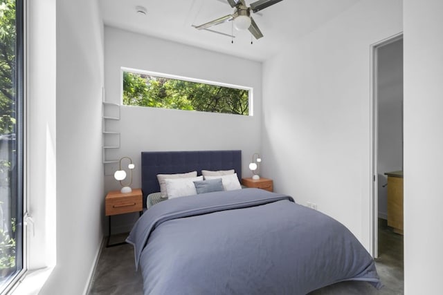 bedroom with ceiling fan and concrete floors