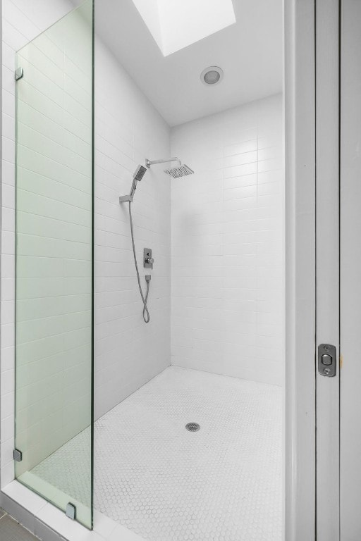 bathroom with a stall shower and a skylight