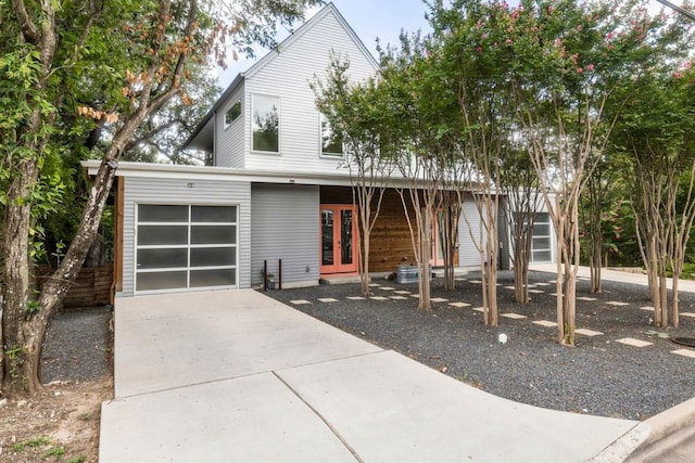 view of front of home featuring a garage, french doors, and driveway